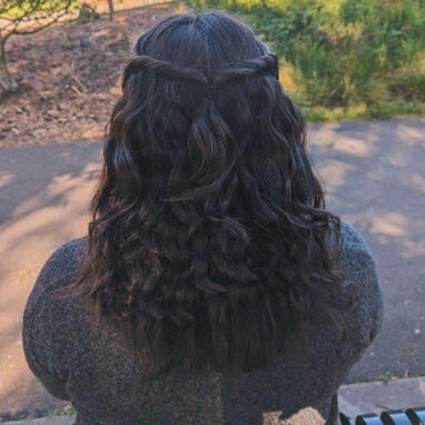 Rayleigh Collins faced away from the camera, her below shoulder length hair is seen worn down.